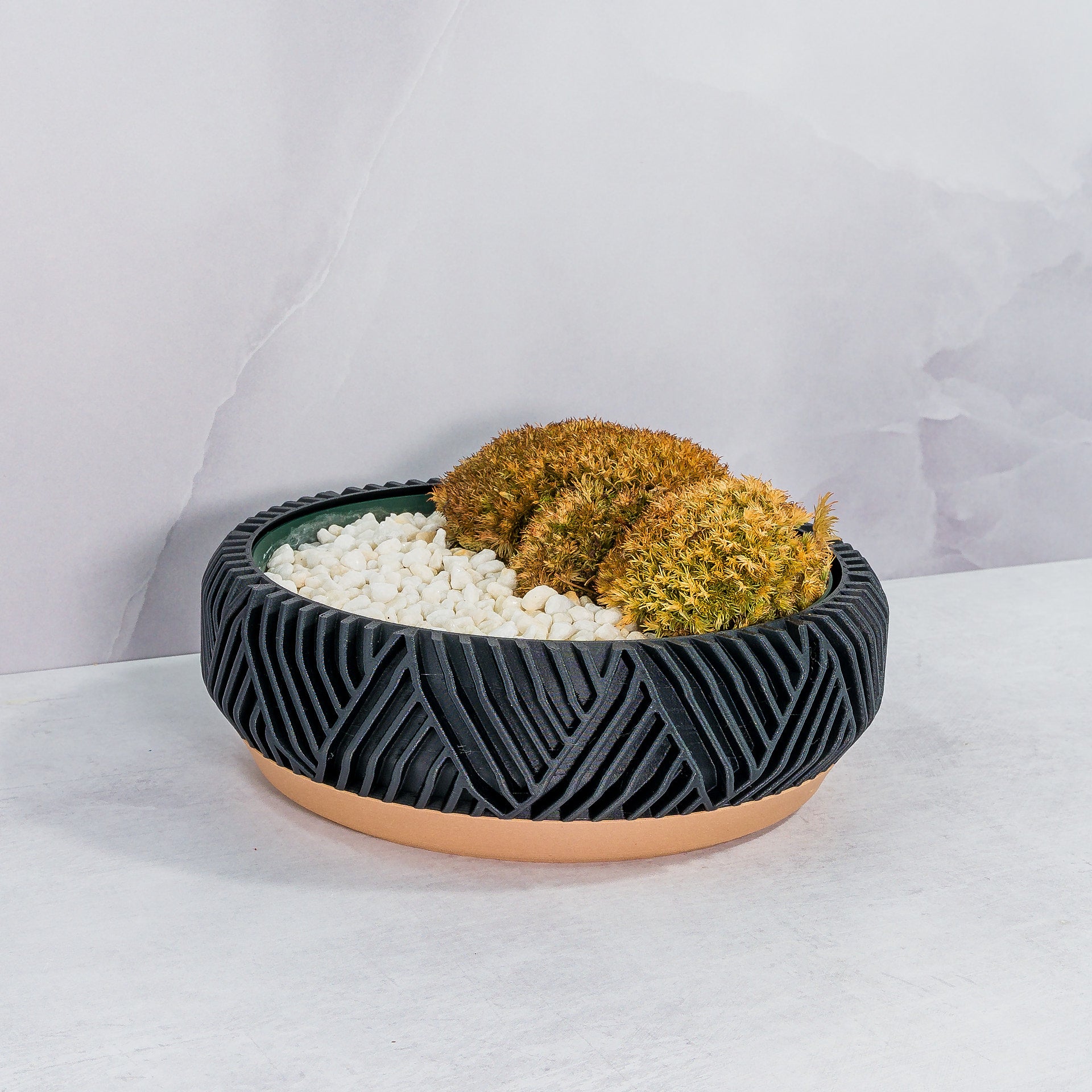 "Angled shot of PEAK bowl planter with moss buns in a fitted insert, showcasing wood and carbon fibre design."
