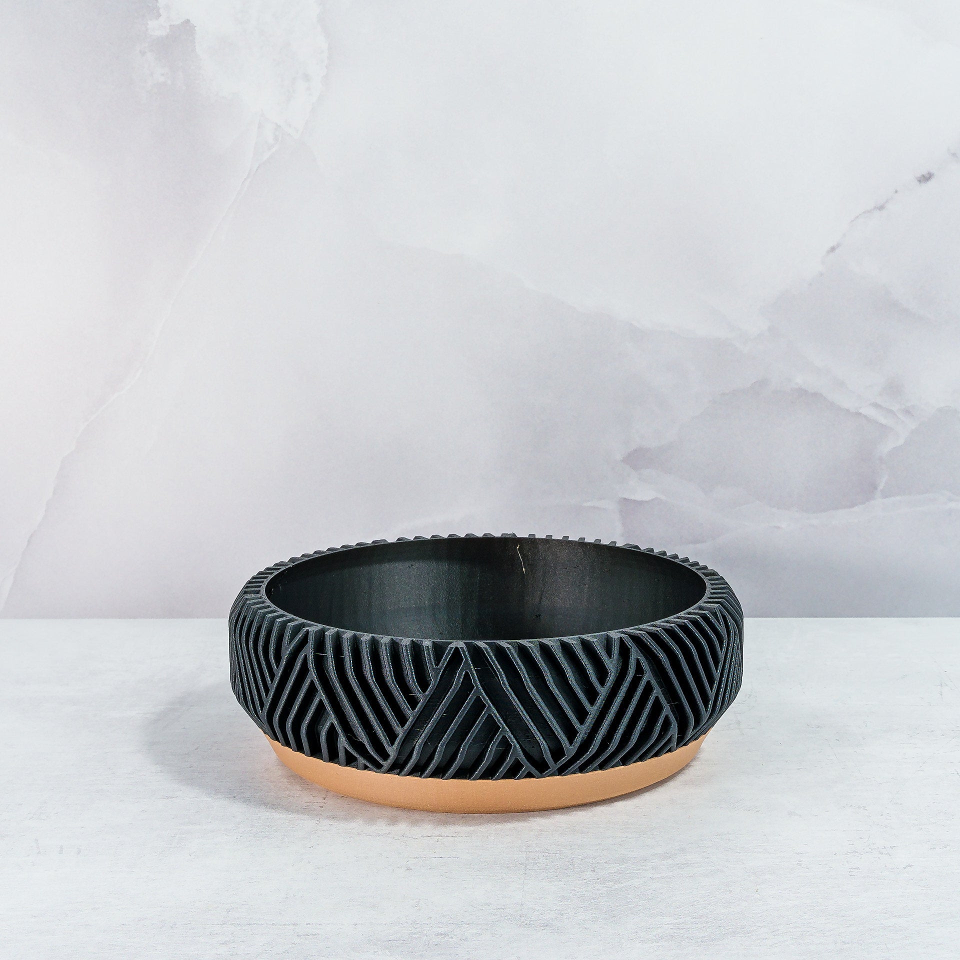 "Empty PEAK bowl planter front view, displaying wood base with striking carbon fibre pattern."
