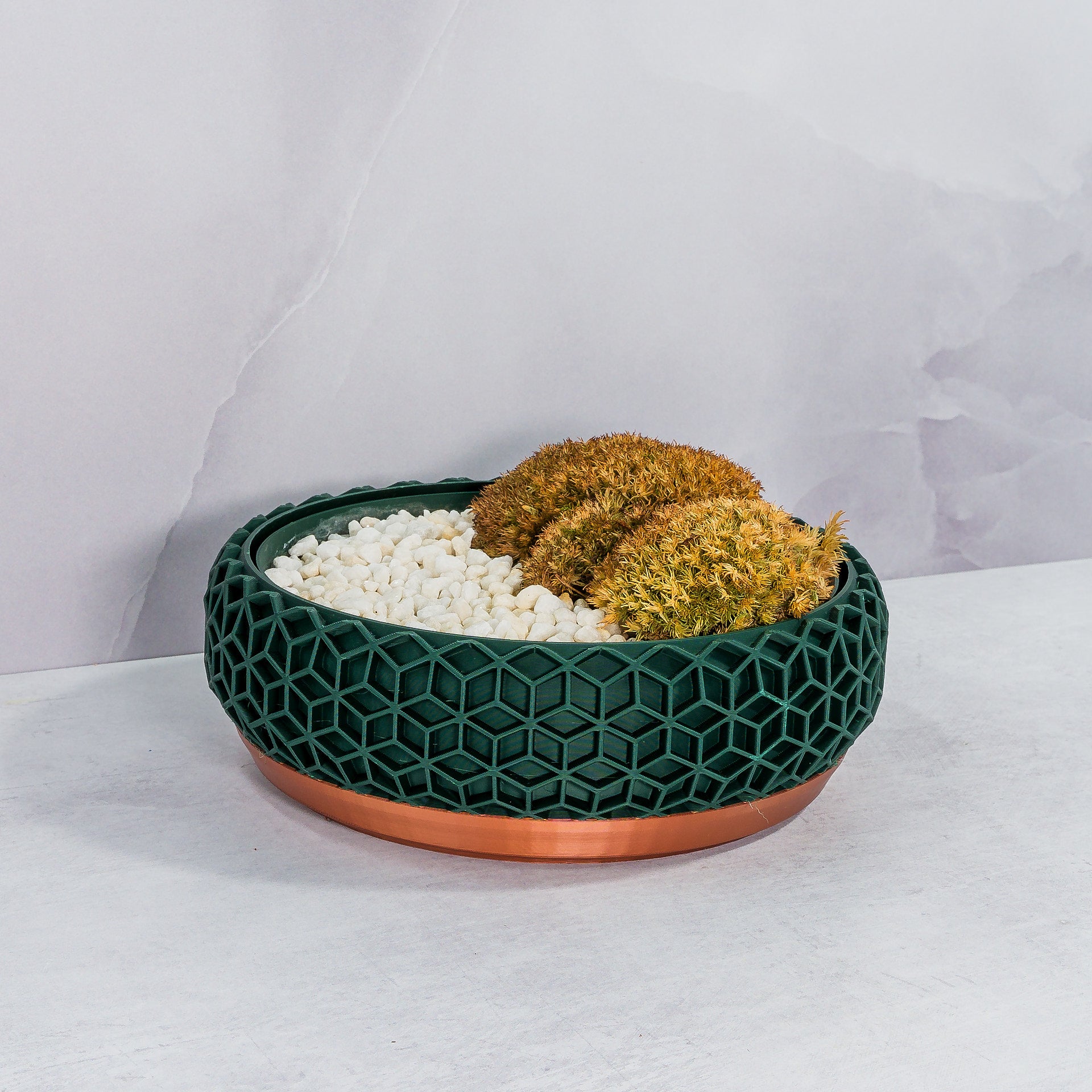 "Angled view of HONEYCOMB bowl planter displaying moss buns in a custom-fit insert, highlighting copper and forest motif."
