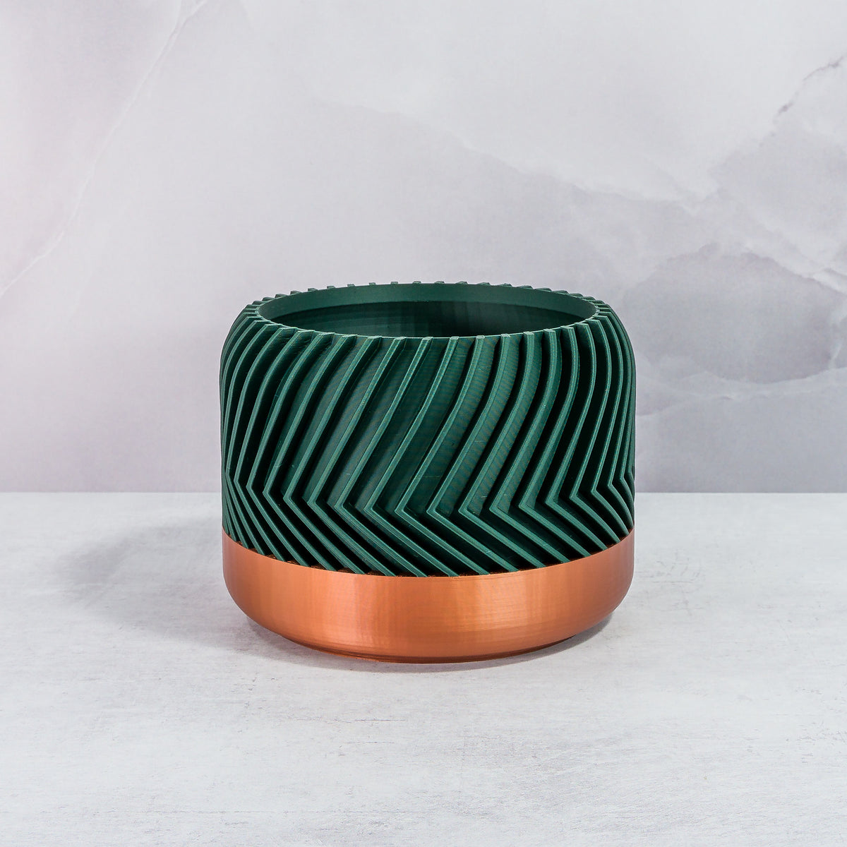 Front Facing: "TREAD planter with copper base and deep green forest pattern, front view."
