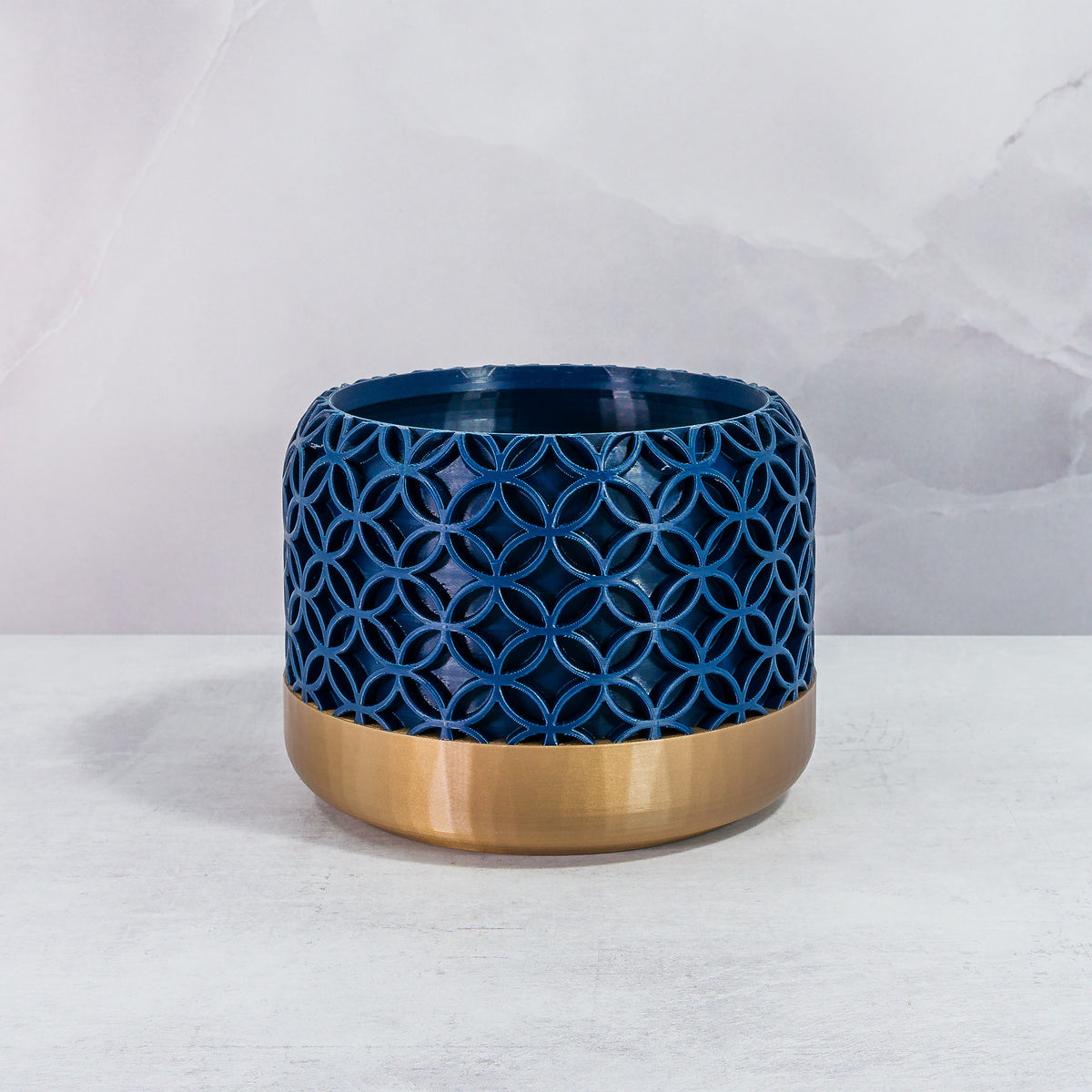 Front Facing: "BLOSSOM planter with gold base and navy pattern, front view."
