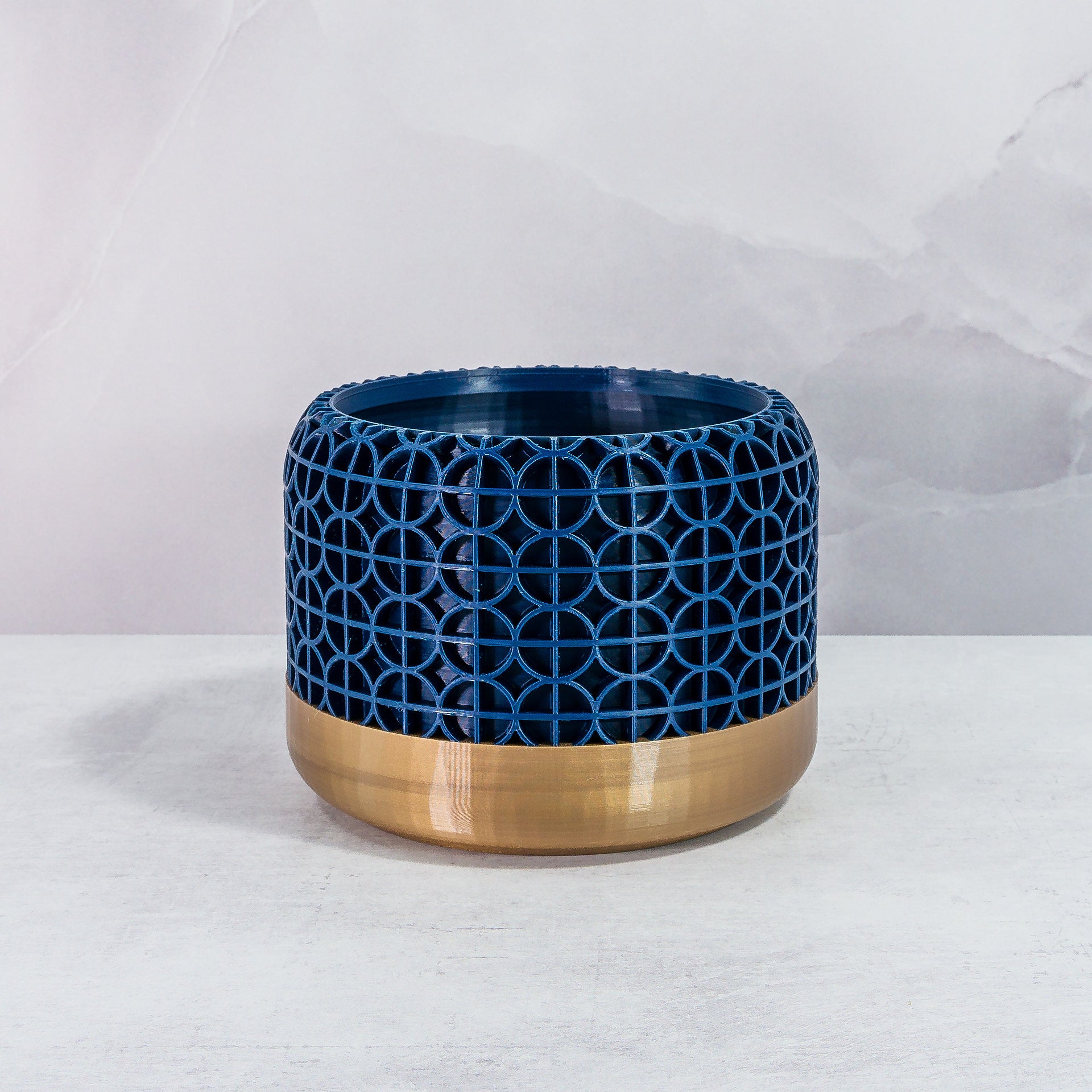 Front Facing: "CROSSORB planter with gold base and navy pattern, front view."
