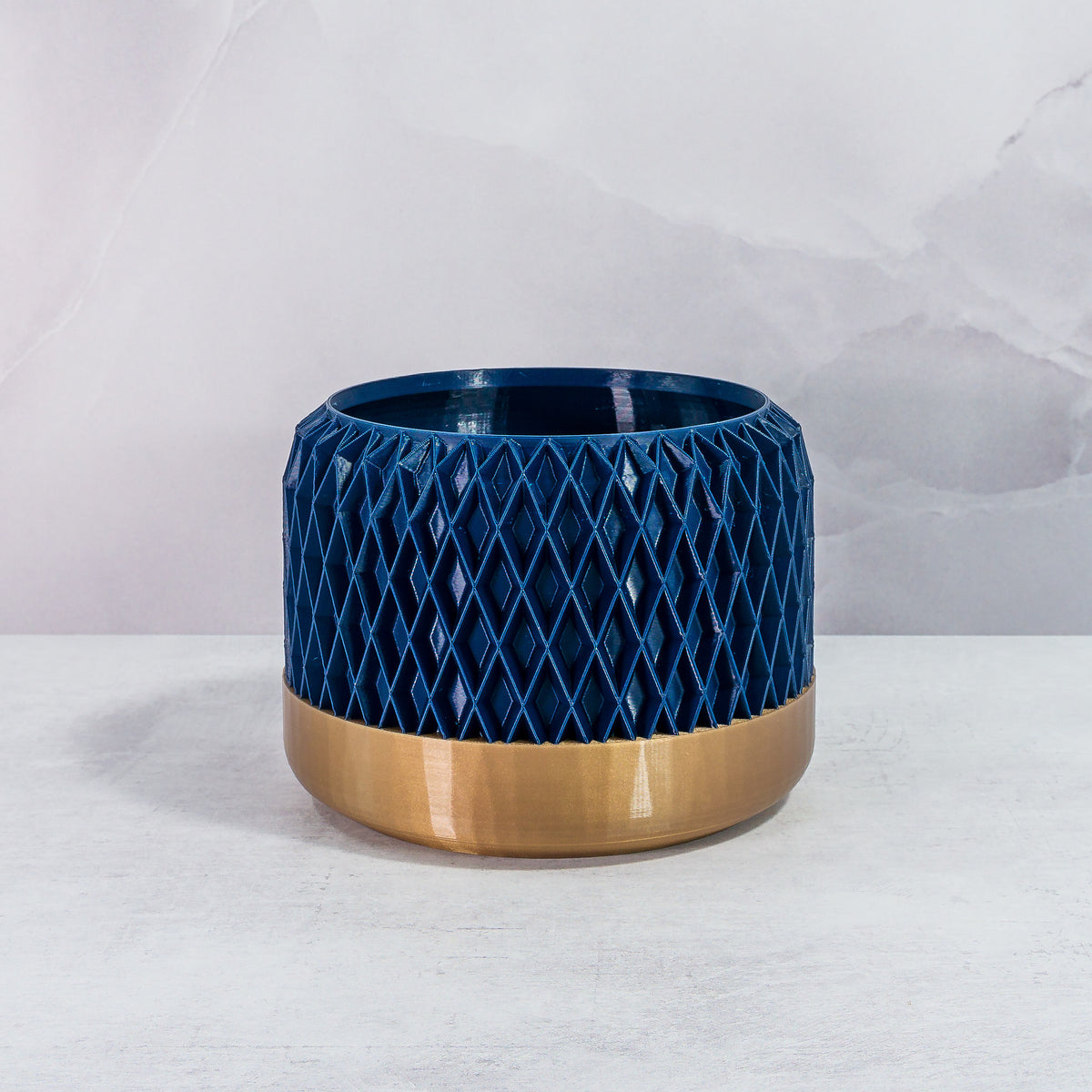 Front Facing: "DIAM planter with gold base and navy pattern, front view."
