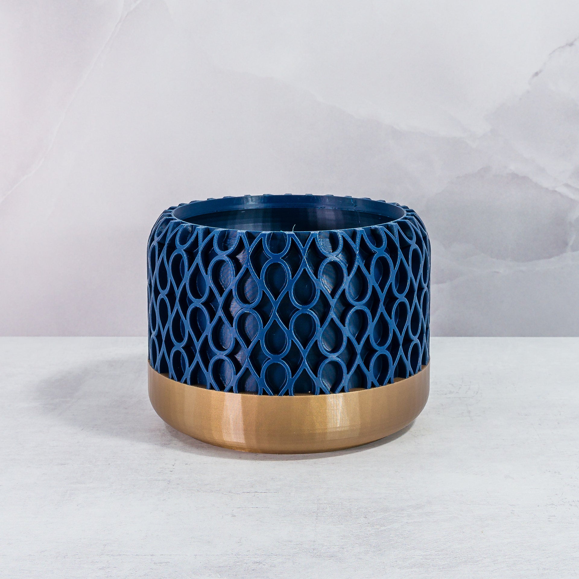 Front Facing: "DROPLET planter with gold base and navy pattern, front view."
