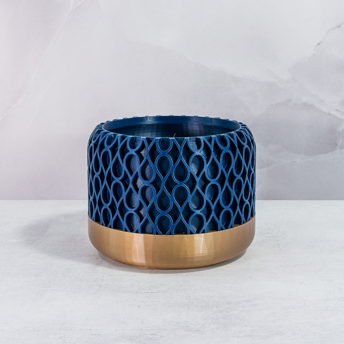 Front Facing: "DROPLET planter with gold base and navy pattern, front view."
