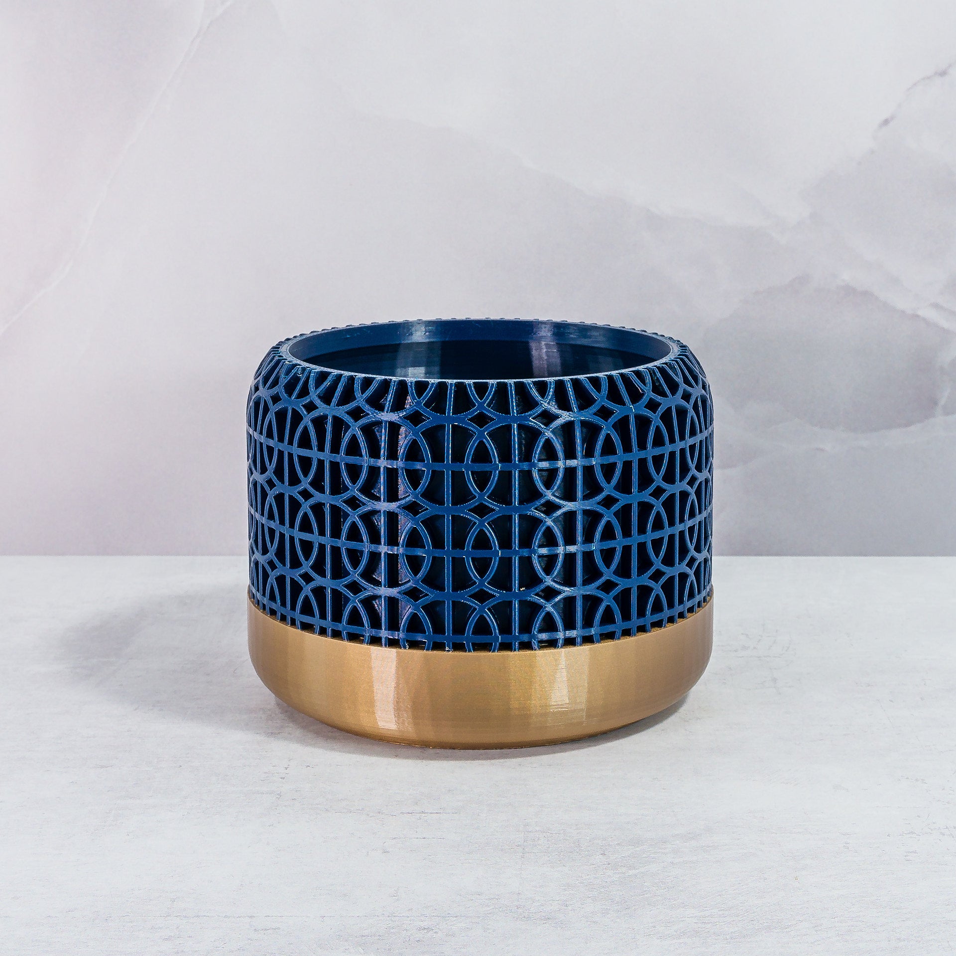 Front Facing: "INTERSECT planter with gold base and navy pattern, front view."
