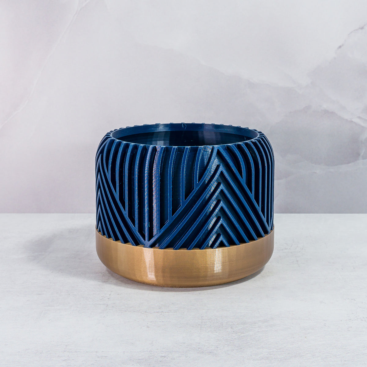 Front Facing: "VERTI planter with gold base and navy pattern, front view."
